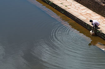 Mann schöpft Wasser in Sri Lanka